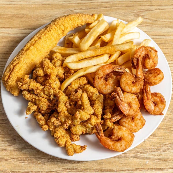A seafood platter from Red Snapper with fried fish, shrimp, oysters, and french fries.